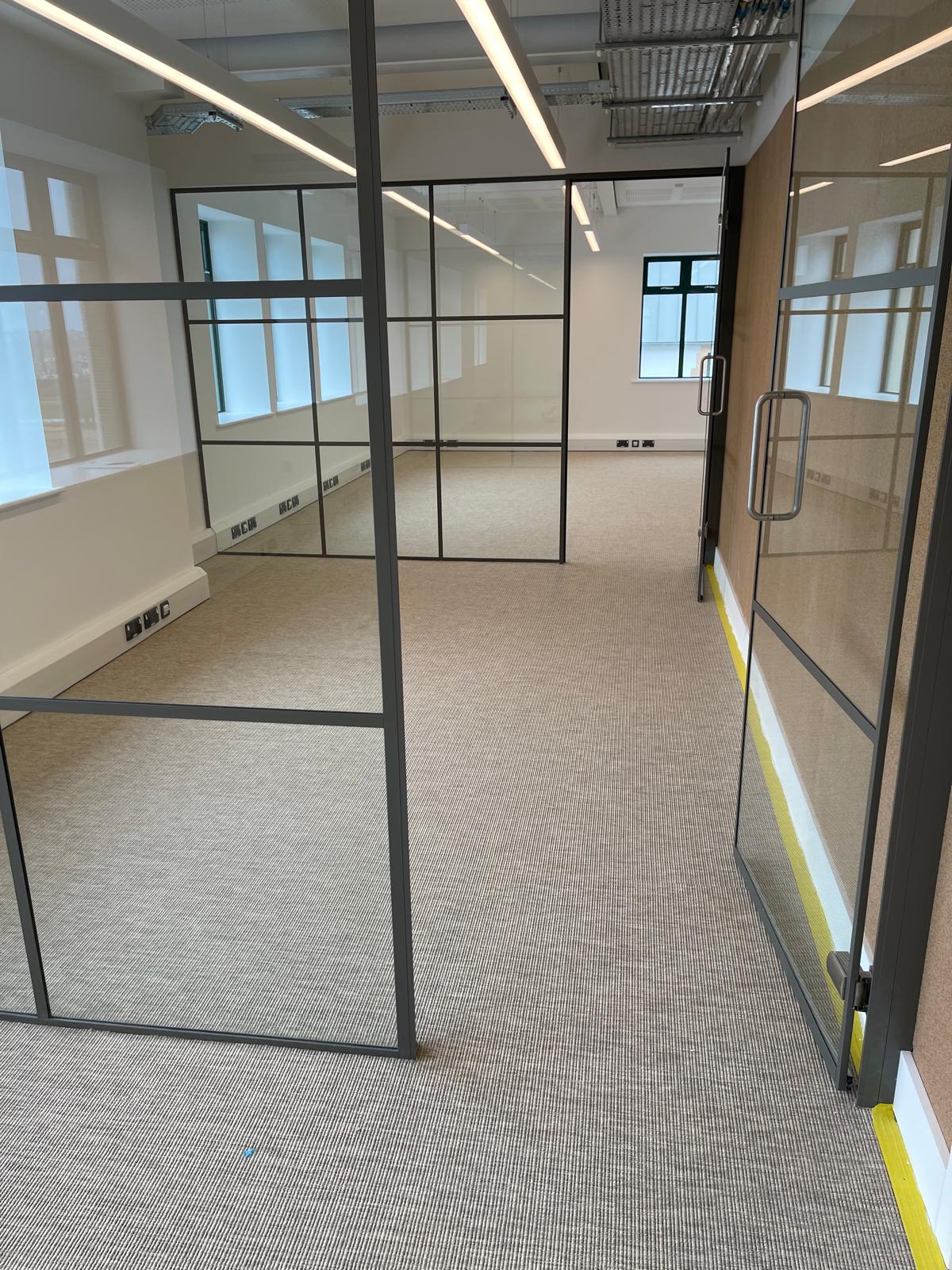 Carpet office 2 Office corridor with grey carpet tiles and glazed partitions