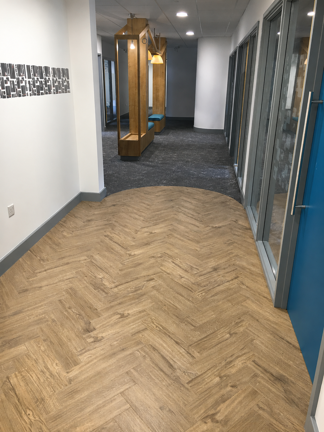 Office corridor with herringbone wood-effect LVT and carpet tiles