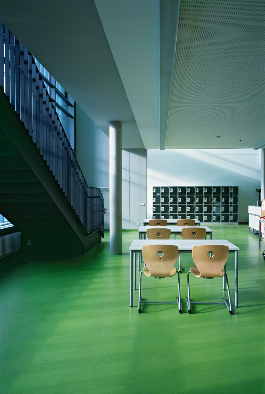 Green linoleum flooring in a school canteen beside a staircase