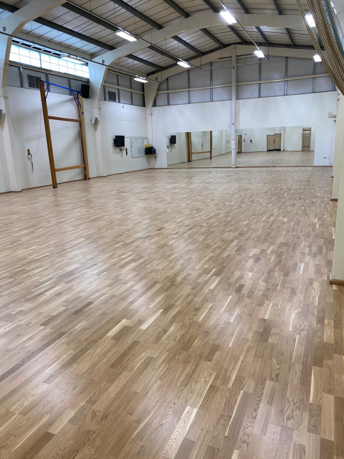 Large dance studio hall with light hardwood sports flooring