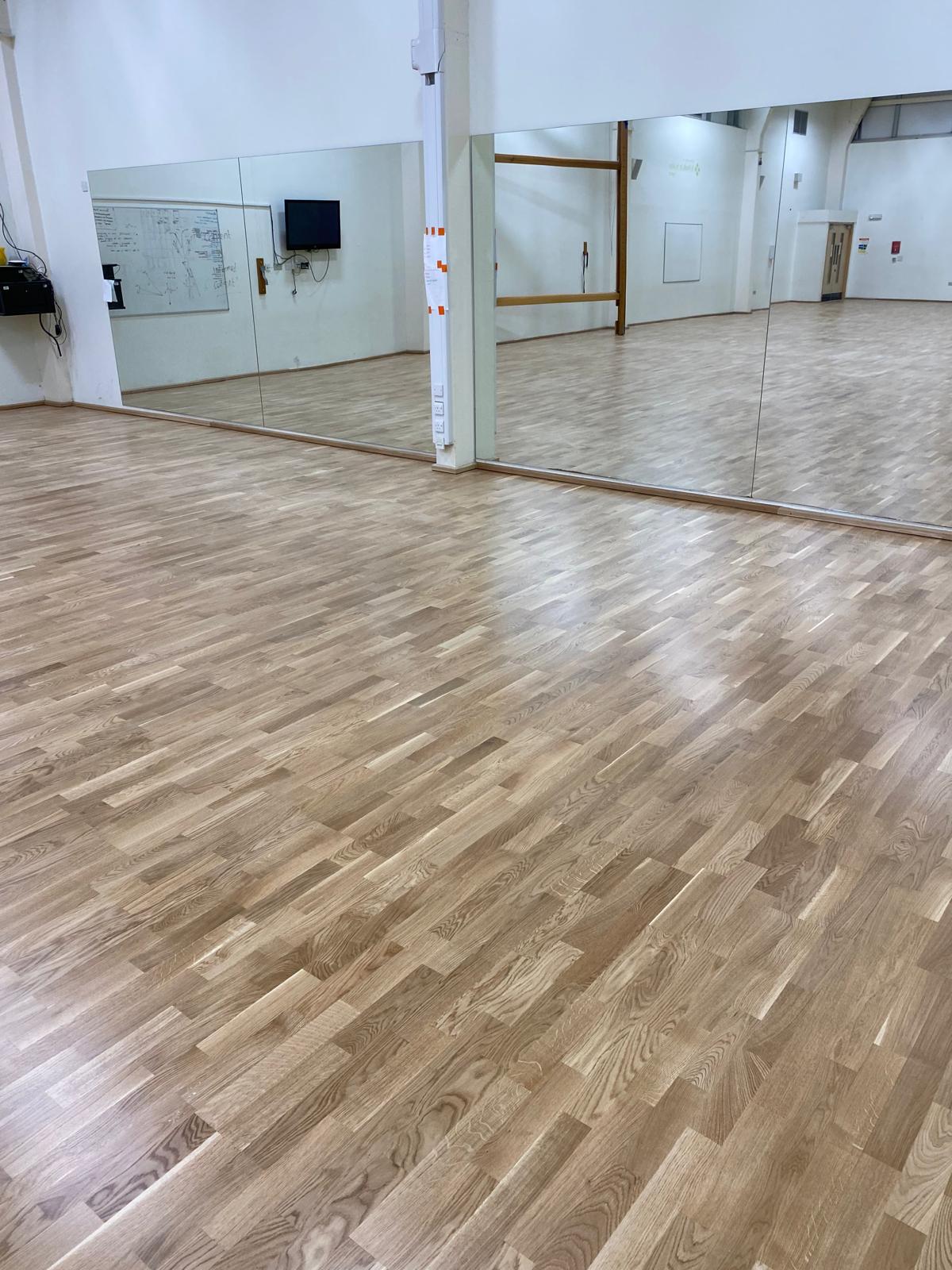 Dance studio with sprung hardwood sports flooring and mirrored wall