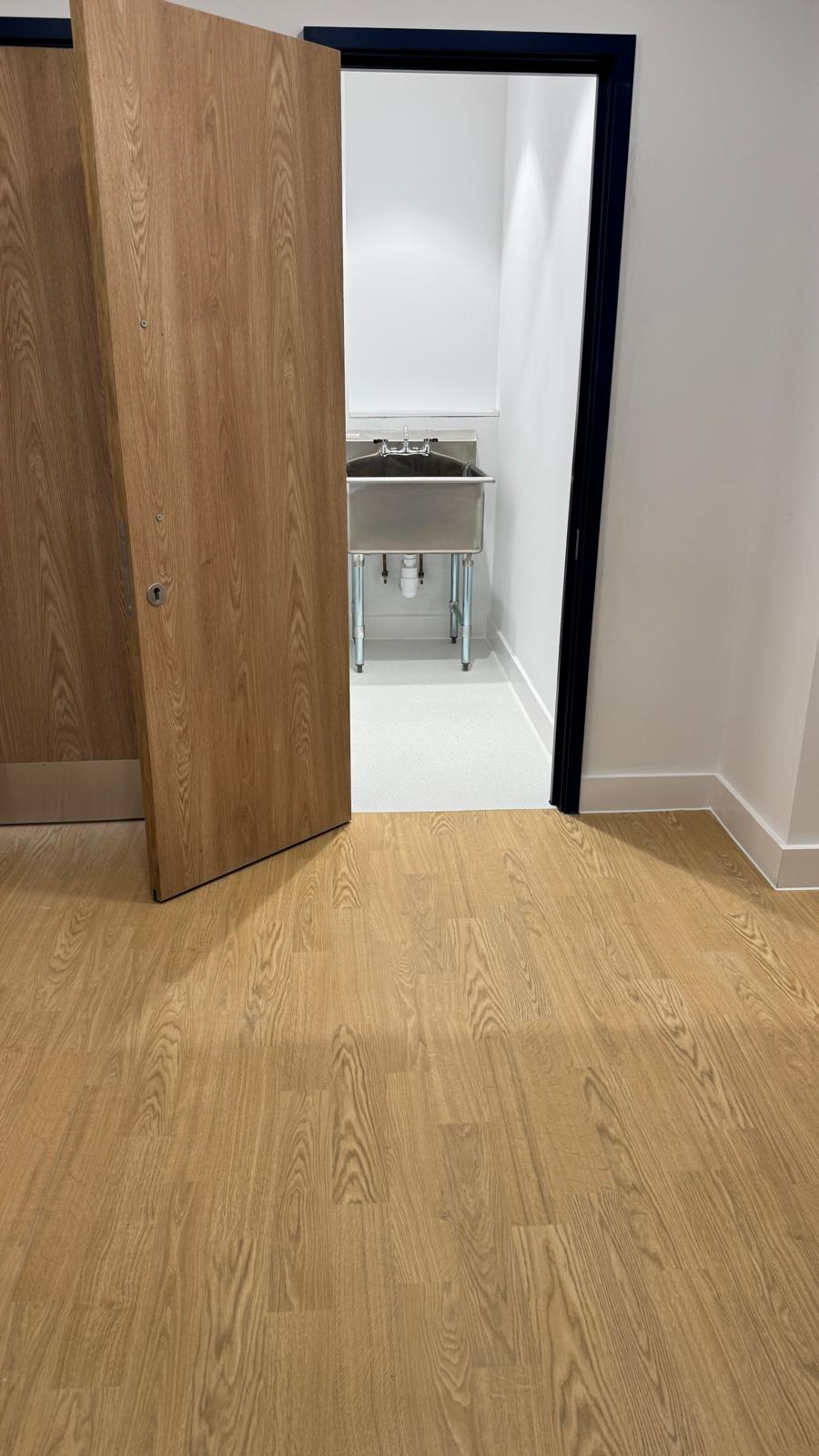 School doorway opening onto light oak-effect vinyl flooring